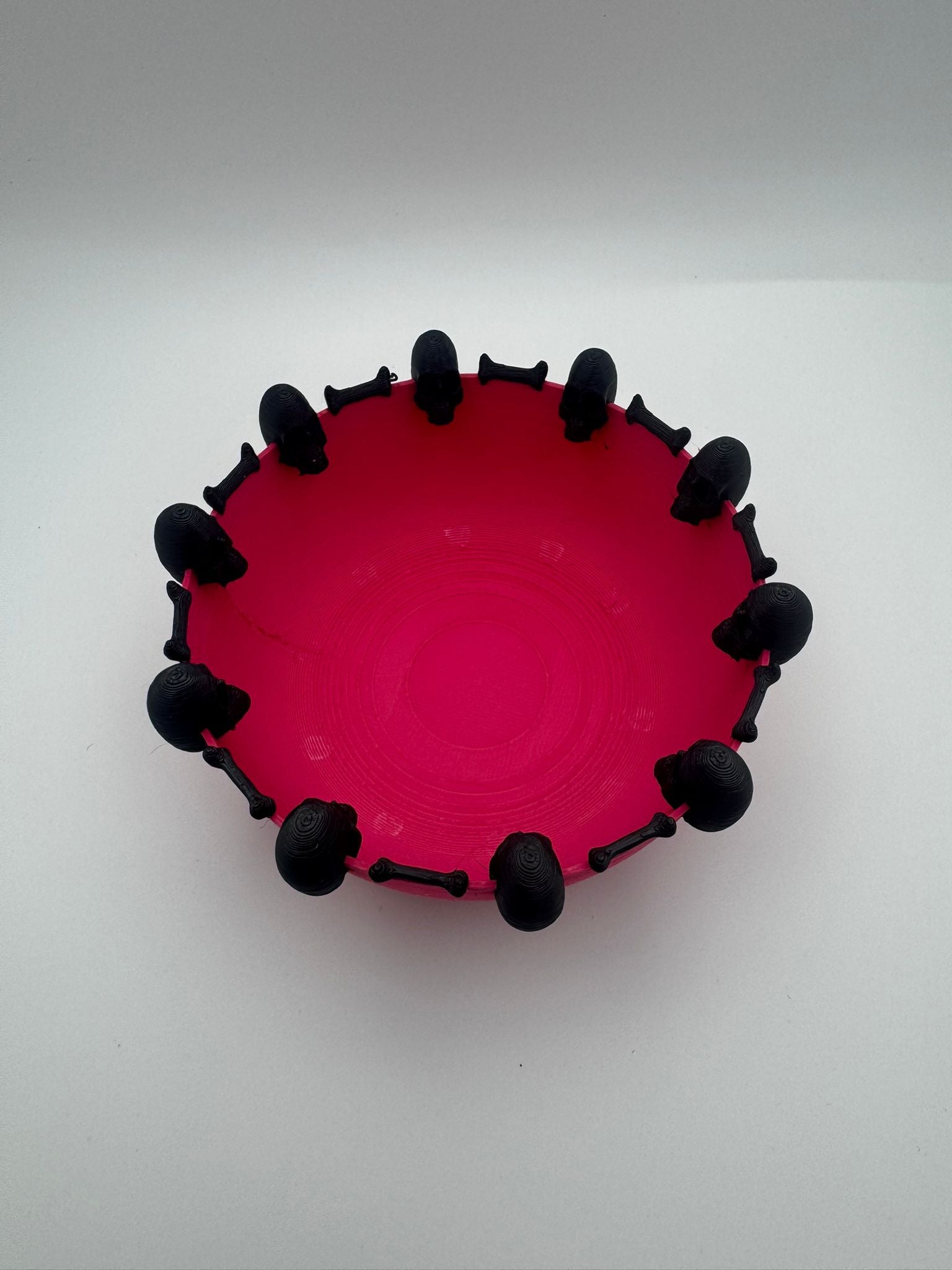 Pink bowl with black spikes on a white background